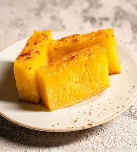 A slice of golden-yellow bika ambon with clearly visible air pockets