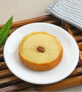Soft-textured cooked potato mud cakes with a golden yellow surface and sweet raisin toppings neatly arranged on a serving plate.