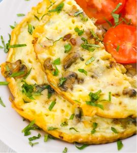 Lipatan telur omelet tebal yang menutupi isian sayuran, sosis, dan keju parut.